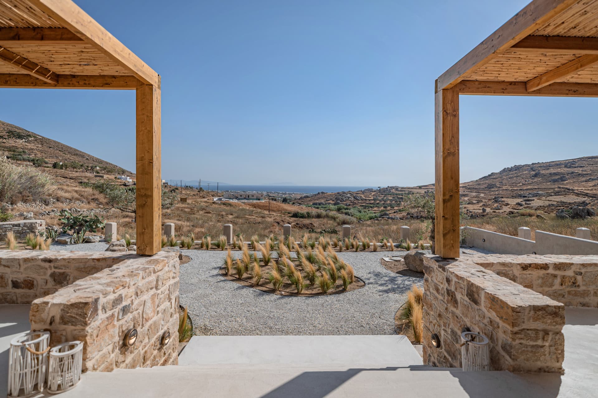 Wooden pergola and stone terrace of Villa A overlooking the Aegean hills above Kastraki, Naxos